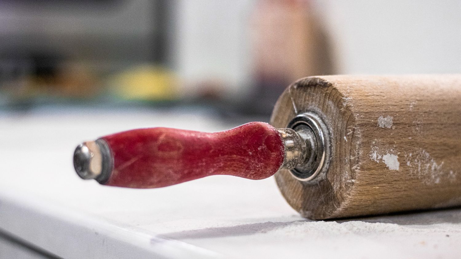 Wooden rolling pin with a red handle