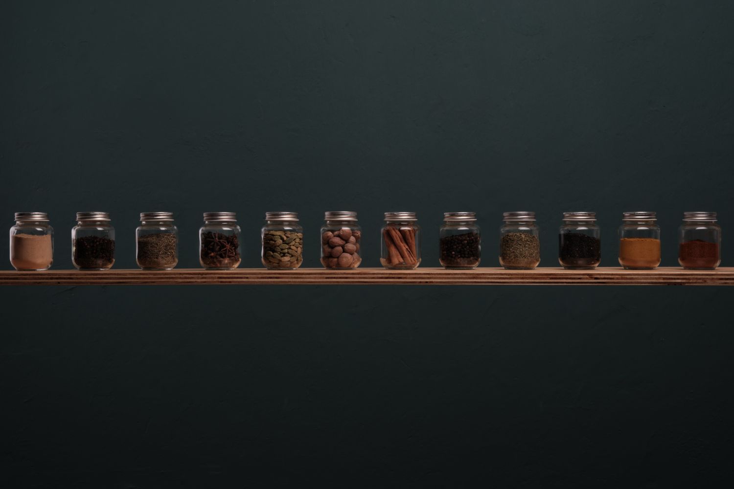 Small spice jars arranged along a shelf