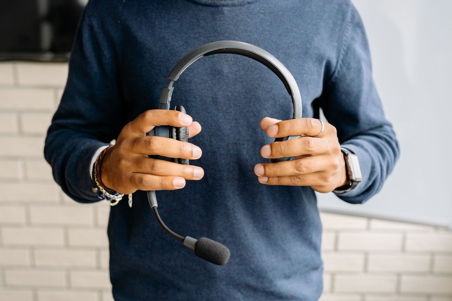 Person hält ein Headset mit Mikrofonarm