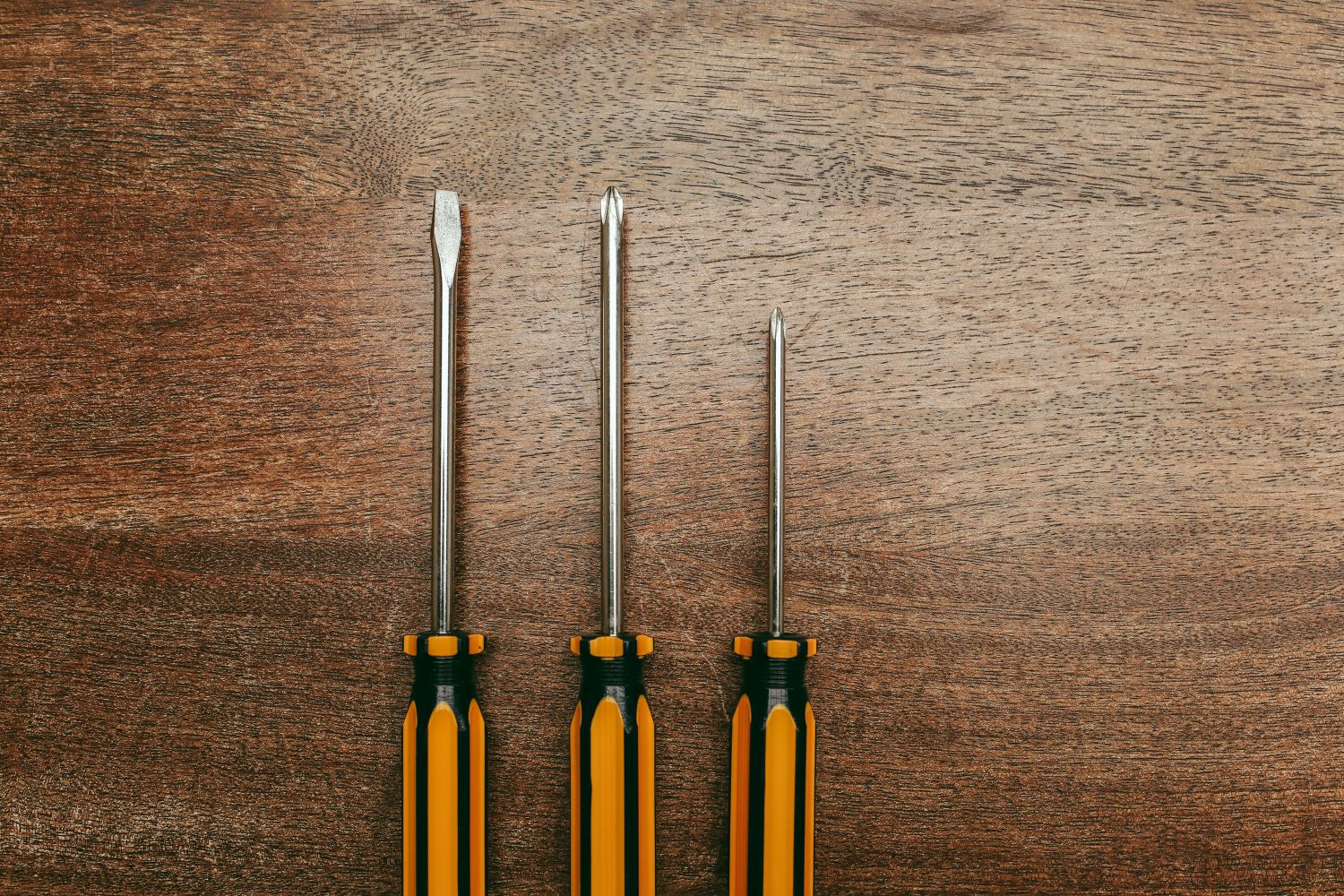 Three screwdrivers on a wooden surface